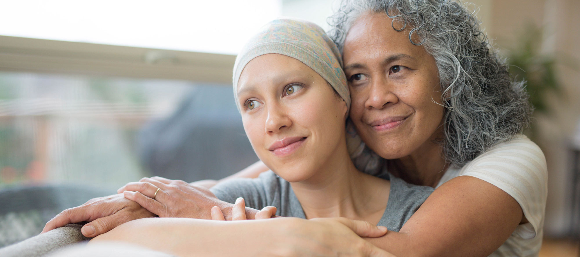 Mom and Daughter hugging. Daughter going through chemotherapy.