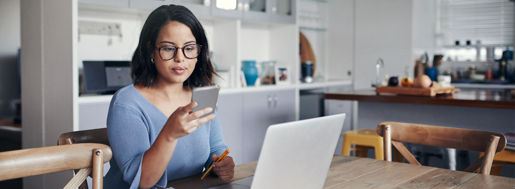 Young woman looking at her cell phone at the table