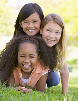 Three young girls playing on the grass