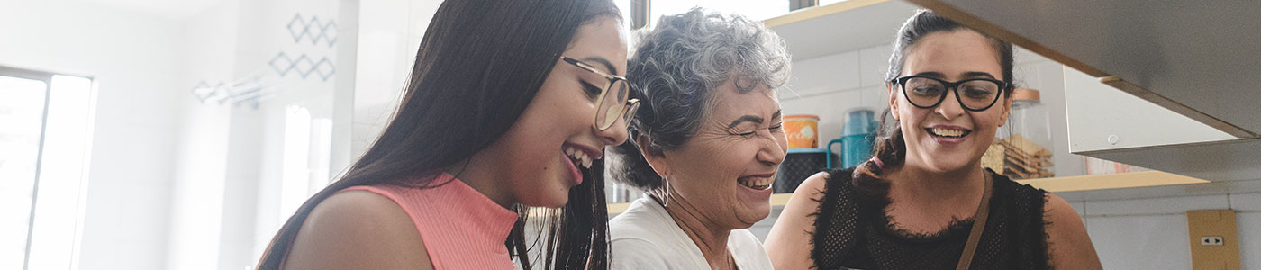 Senior woman cooking with two younger women