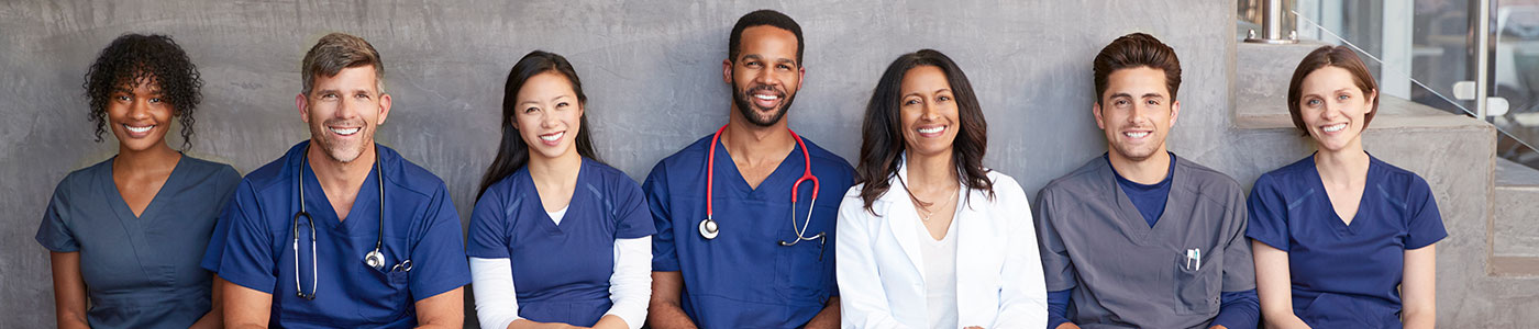 7 medical providers sitting down looking at camera